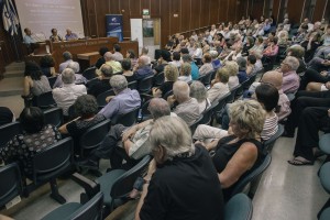 IMG_6093 (1) מבט על מהצד על הטקס, רואים את האולם מלא באורחים ואת חברי הפאנל מיכה וברכה ישובים במקומם ומנכ"ל ארגון כל זכות בנאום קבלת הפרס